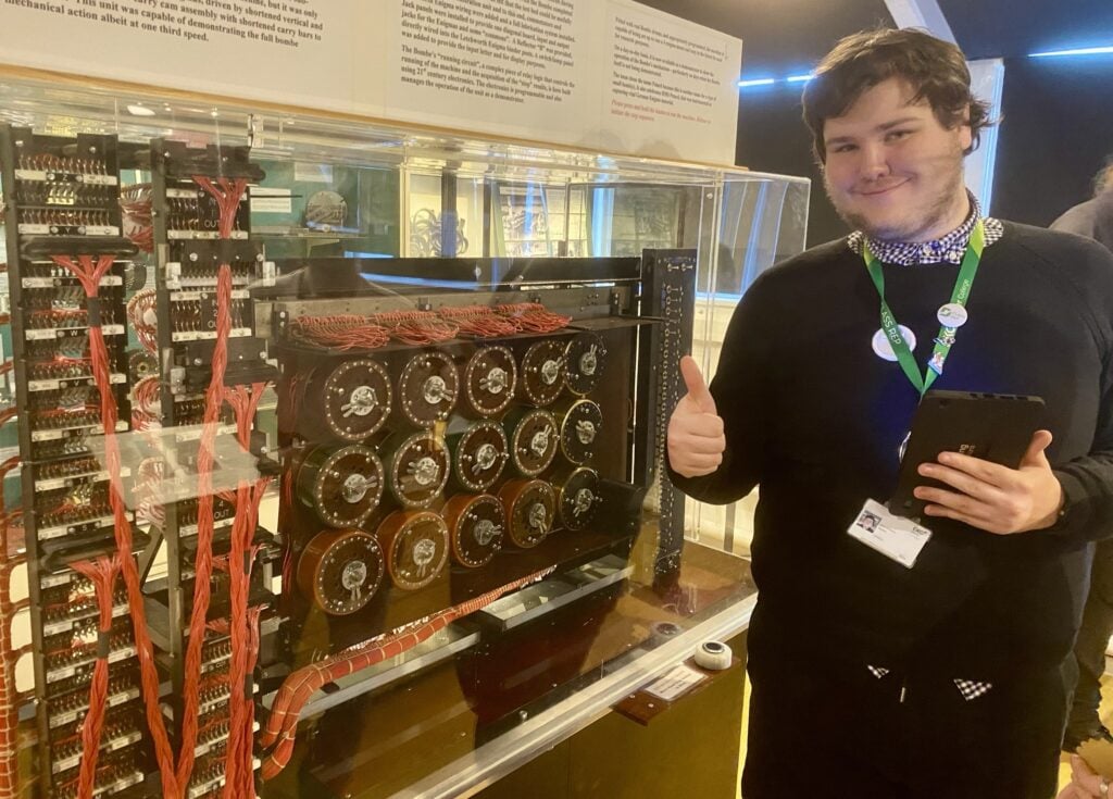 a student stands in front of an old computer system