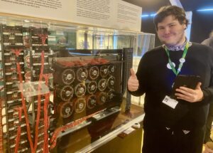 a student stands in front of an old computer system