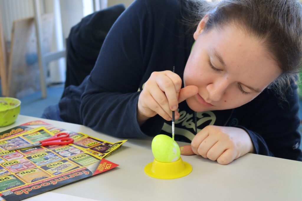 student paints an egg