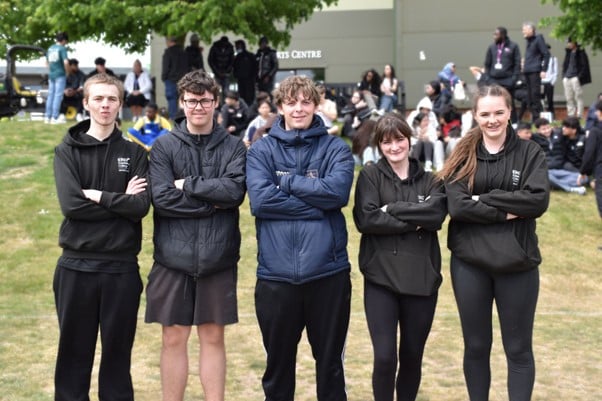 5 students stood with their arms crossed