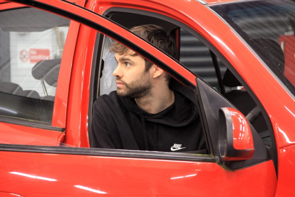 automotive student in red car