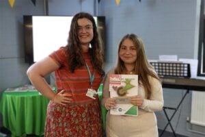 Student and presenter with award smiling at camera