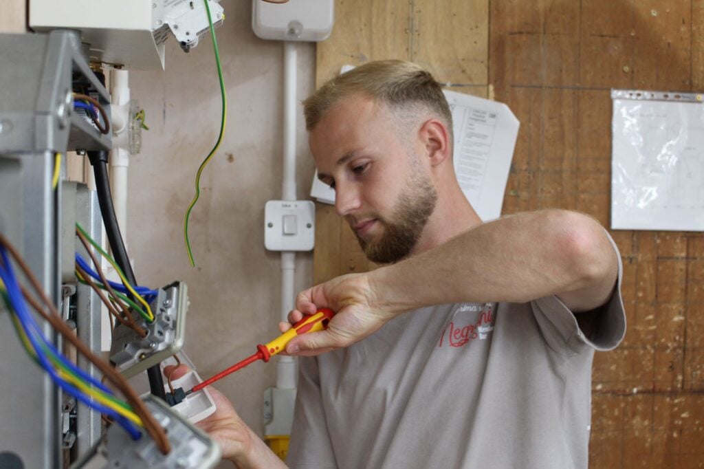 Man using a screwdriver to fix a plug