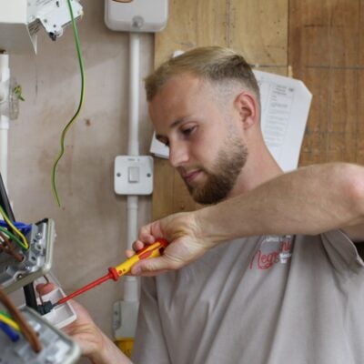 Man using a screwdriver to fix a plug