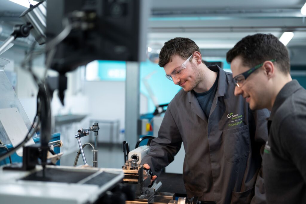 2 students working on a machine in an engineering workshop