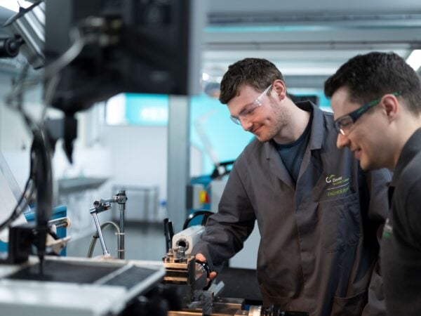 2 students working on a machine in an engineering workshop