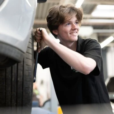 Student changing a car tire