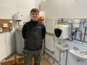 Young man stood in plumbing workshop