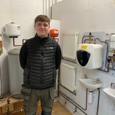 Young man stood in plumbing workshop