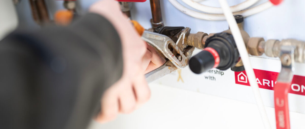 Student holding tool to cut pipework for plumbing equipment