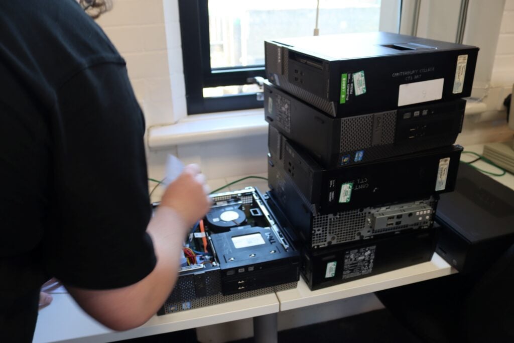 a student checks old IT equipment in a computing workshop