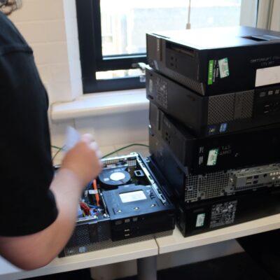 a student checks old IT equipment in a computing workshop