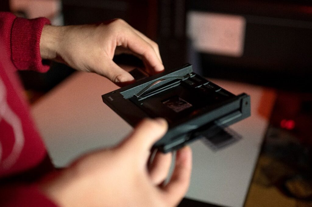 Hands holding an enlarger to look at film