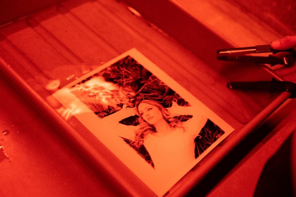 A photograph developing in a tray