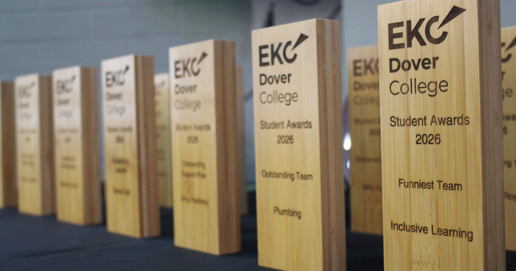 The Dover Student Awards lined up on a table. They are made of recycled wood and engraved with the logo and award on the front.
