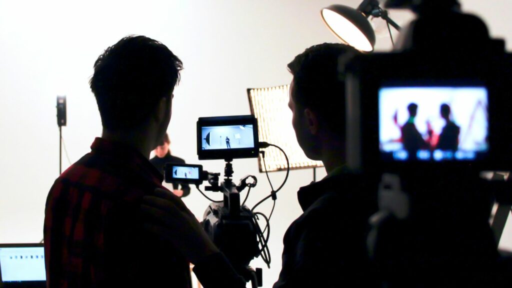 students looking through a camera on a film set