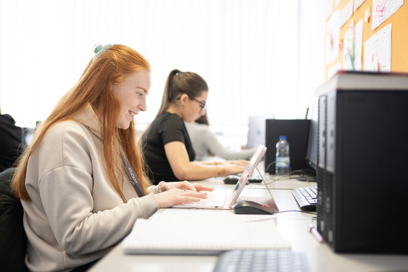 a female student looks at a computer