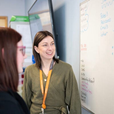 a business lecturer looks at a white board
