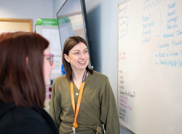 a business lecturer looks at a white board