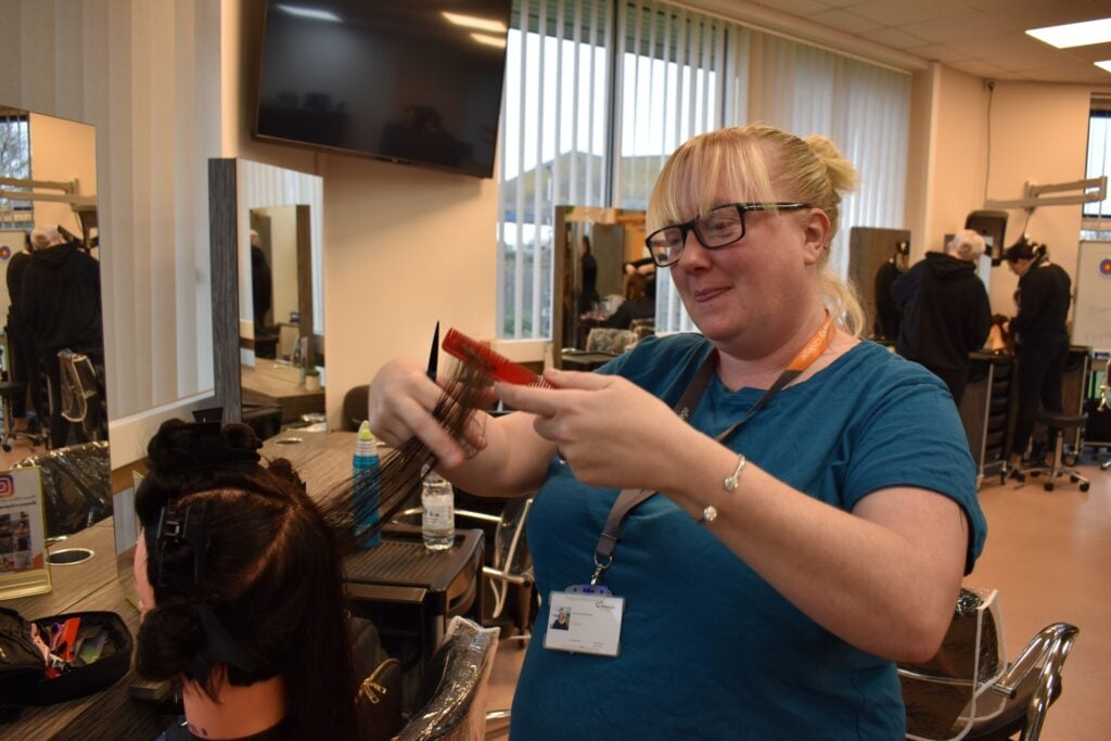 hair dressing adult student works on client's hair