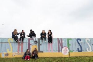 students sitting outside on a Sheerness sign