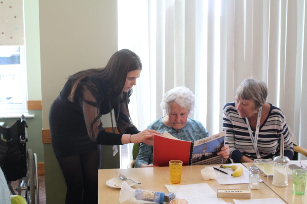 a student helps adults in a care home