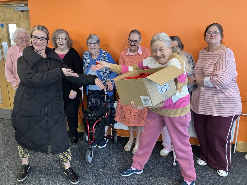 Poppies being handed over by Knit and Natter, to Business Lecturer, Tania.
