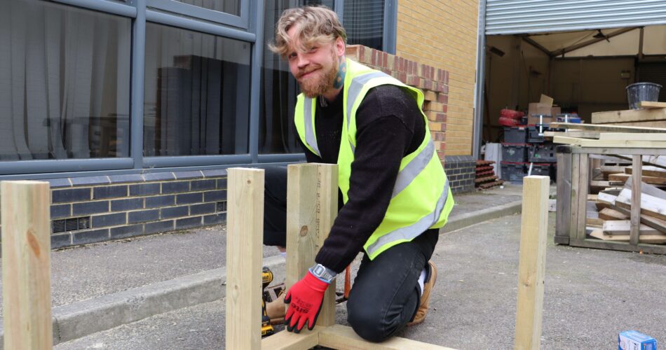 Leonard kneeling with wooden structure