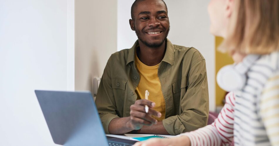 man sat at laptop smiling