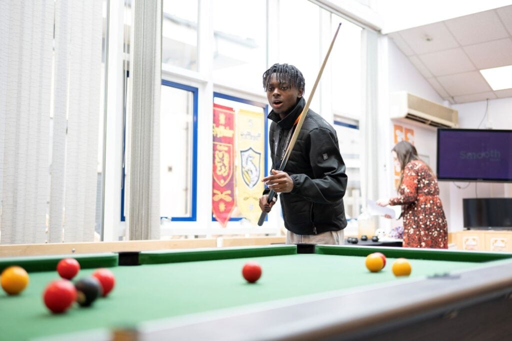 Student plays pool at EKC Sheppey College