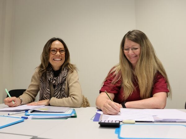 two female adult learners laughing in a classroom
