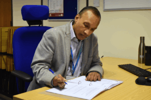 a lecturer sits at his desk