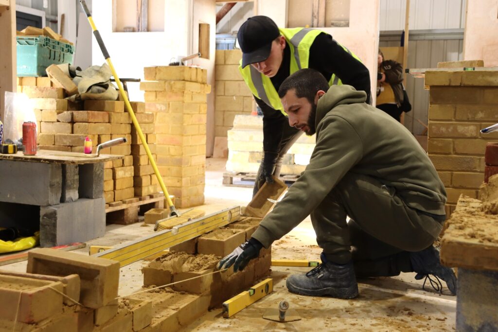 bricklaying student working with tutor