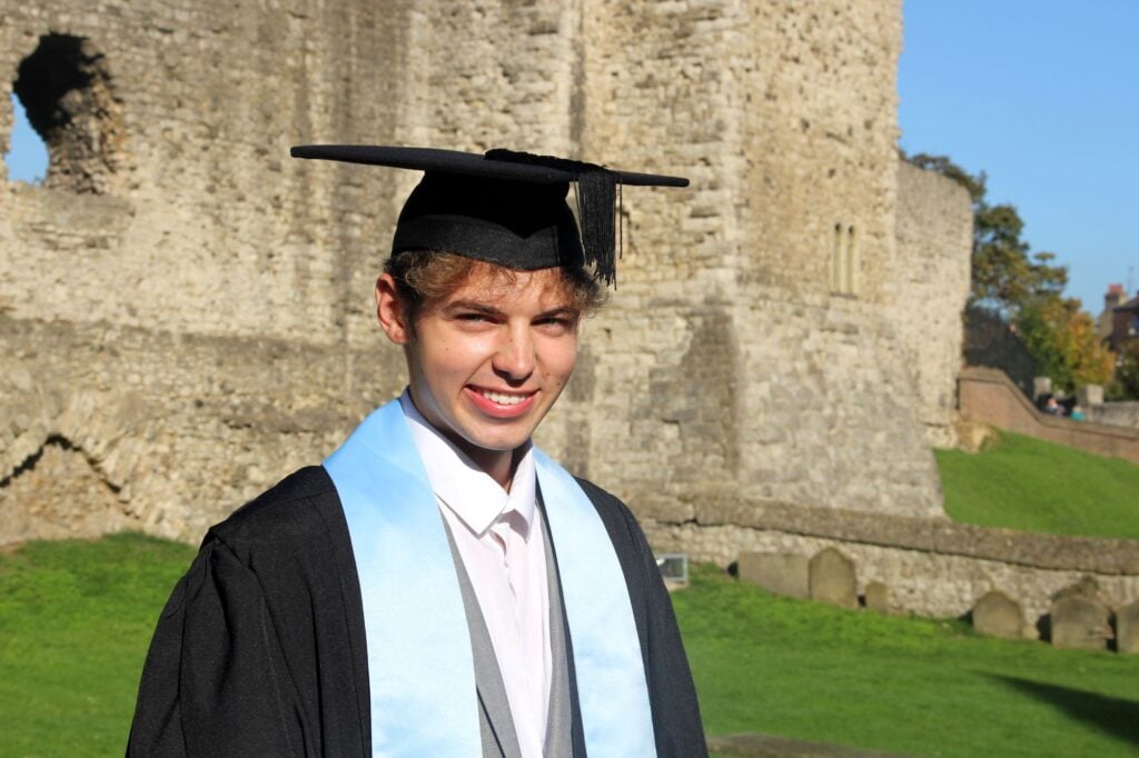 Young man standing outside wearing a graduation cap