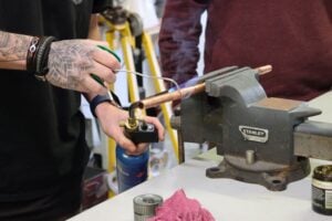close up photo of someone soldering copper pipe