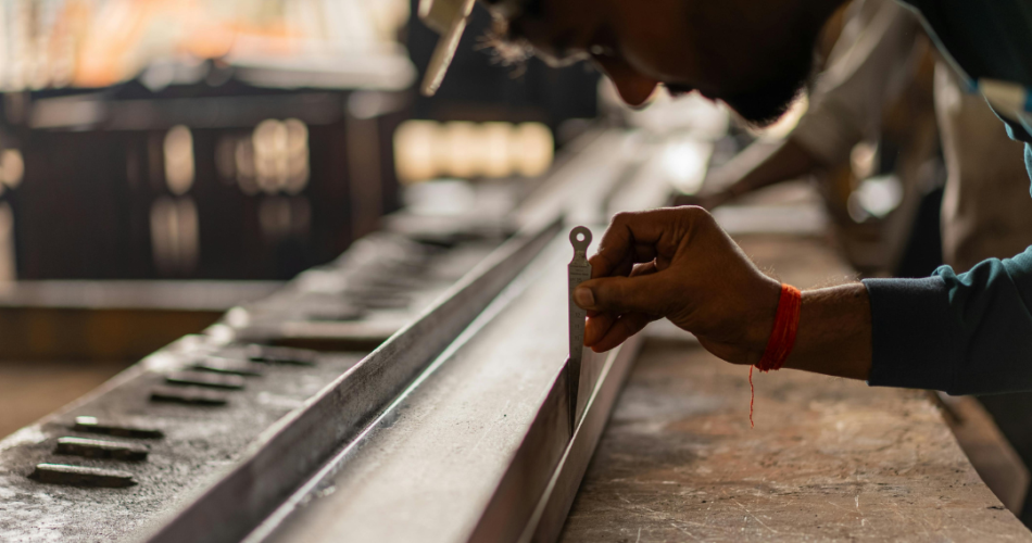 A fabricator checking the measurement of a steal beam