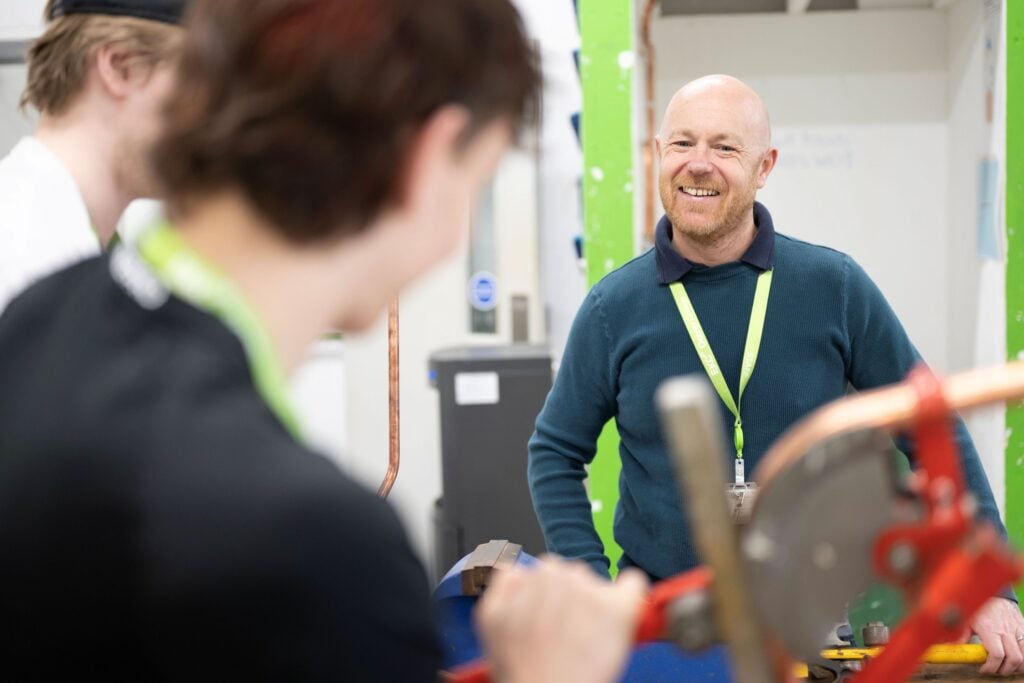 Tutor looking over at students smiling