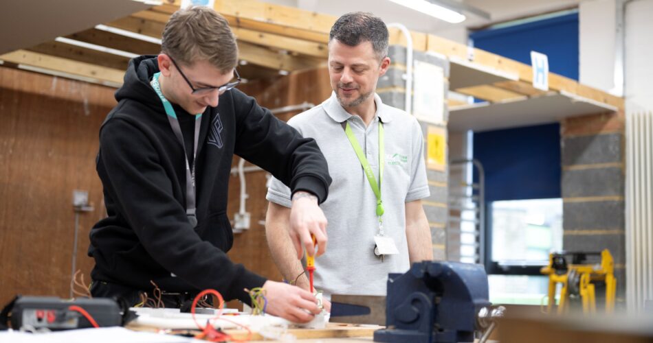 Student using a screwdriver. Tutor observing.