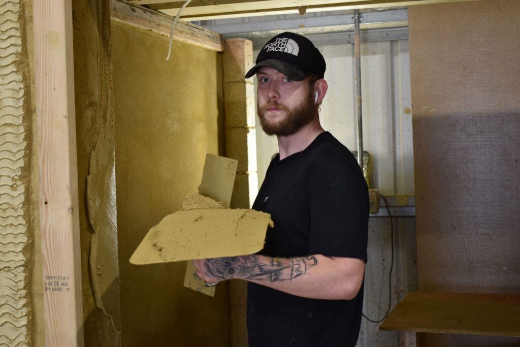 Student plastering a wall