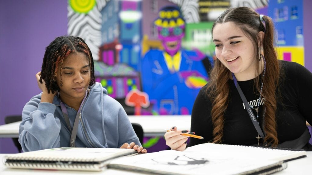 two art and design students sat with a sketchbook open