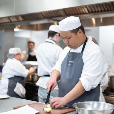 students chops food in a professional kitchen