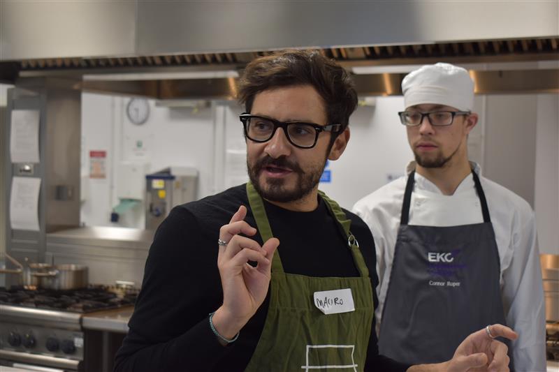 Students listen in on a lesson in the kitchen.
