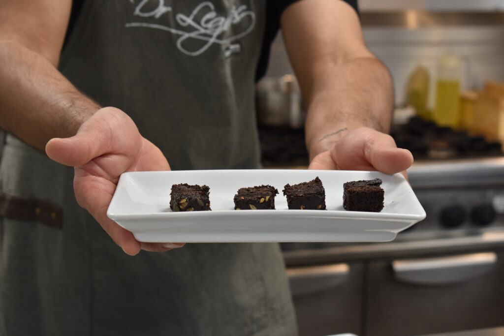 A College student displays his baked item on a dish.