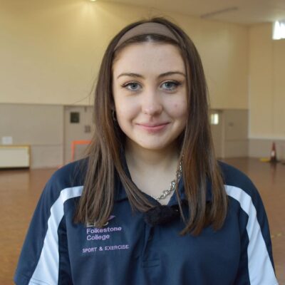 Sport student smiling at camera in a sports hall
