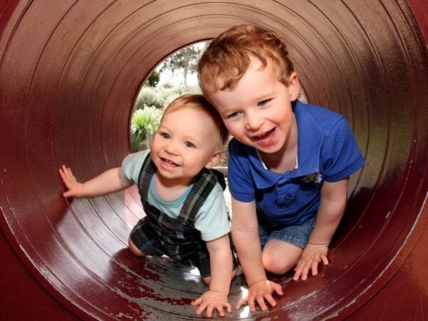 Baby and toddler playing in a tunnel