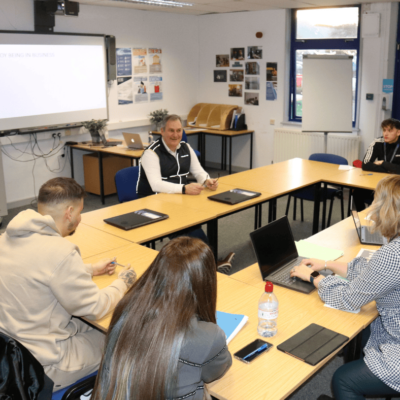 Students and lecturer in a business meeting.