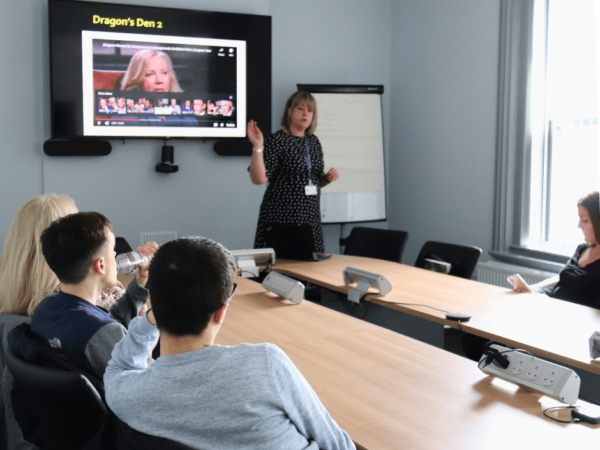 In the boardroom presenting via a television to students.