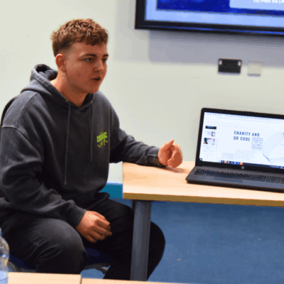 student sat presenting on laptop