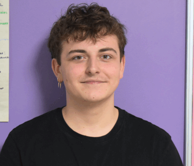 Our student, Oliver, smiling looking at the camera.