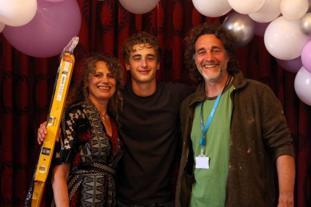 Max smiling with his parents